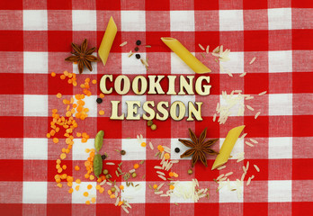 Fototapeta premium Cooking lesson written with wooden letters on checkered cloth and cooking ingredients 