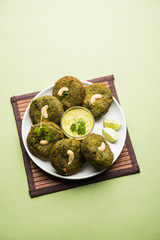 Hara bhara Kabab or Kebab is Indian vegetarian snack recipe served with green mint chutney over moody background. selective focus
