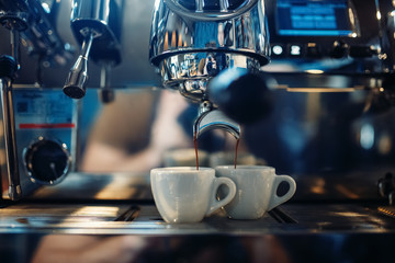 Coffee machine pours fresh espresso into the cups