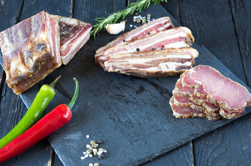 Slicing jerky meat on a black tray.