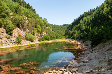 Fototapeta premium Beautiful lake in a small canyon surrounded by forest and woodland (Blaencuffin, Wales)