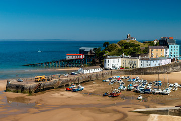 Colorful buildings and boats aground in harbour during low tide (Tenby, West Wales, UK)