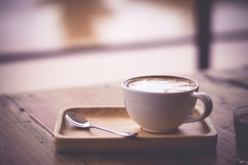 Cup of coffee on wooden table vintage tone.