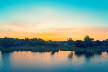 Fototapeta na wymiar Village by the lake at sunrise