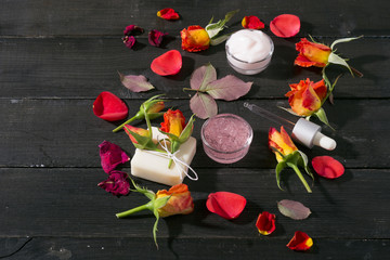 beauty products with roses on black wooden