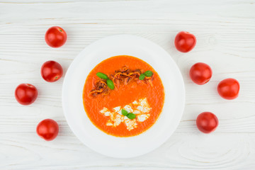 tomato soup on a wooden background, top view