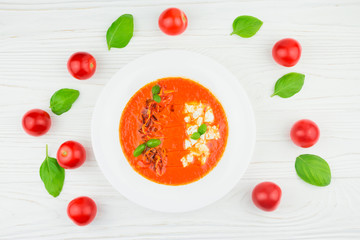 tomato soup on a wooden background, top view