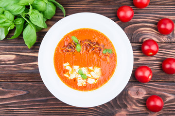 tomato soup, on a wooden background, top view