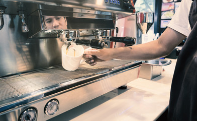 Barista made drink by coffee machine with vintage tone.