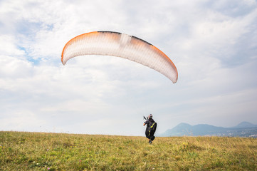 The paraglider opens his parachute before taking off from the mountain in the North Caucasus. Filling the parachute wing with air before takeoff