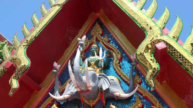 Sculpture of Hindu god Indra sitting on three-headed elephant Airaavatha decorating facade of Wat Phra Yai, Koh Samui island, Thailand. Decoration of temple exterior depicting Buddhist guardian deity.
