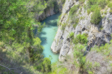 Tourist village of Montanejos (Castellon - Spain). Mijares, mountain river with thermal and medicinal waters. Near to swimming area of "The bathes spring", on summer season. Soft focus.