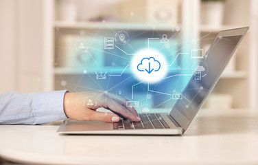 Business woman in homey environment using laptop with  online storage and cloud technology concept
