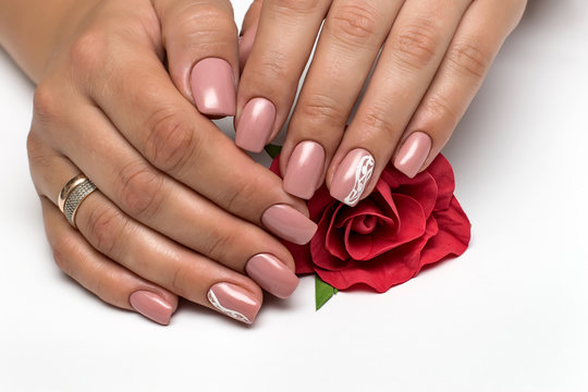 light pink manicure with white painting, stripes, abstraction on nameless nails on long square nails with a red rose in hands