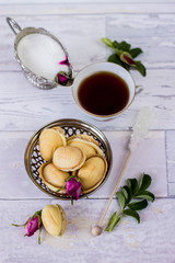 cup of tea, white sugar, sugar cane, wild rose petals and homemade cookies called nuts - flat lay background