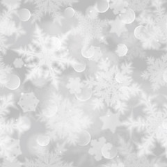 Christmas seamless pattern with white blurred snowflakes, glare and sparkles on gray background