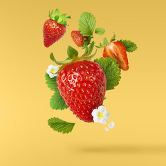 Flying Fresh tasty ripe strawberry with green leaves