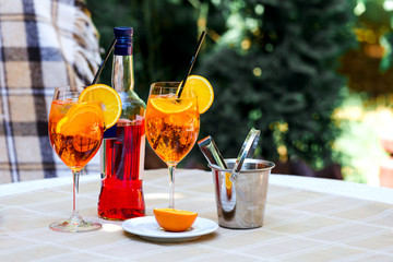 Aperol spritz cocktail glass plaid table leaves sun orange ice bucket shadow sunlight