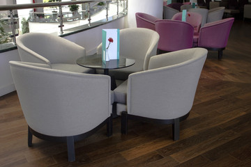 Business Interior. Brown parquet, beige leather sofas and glass table