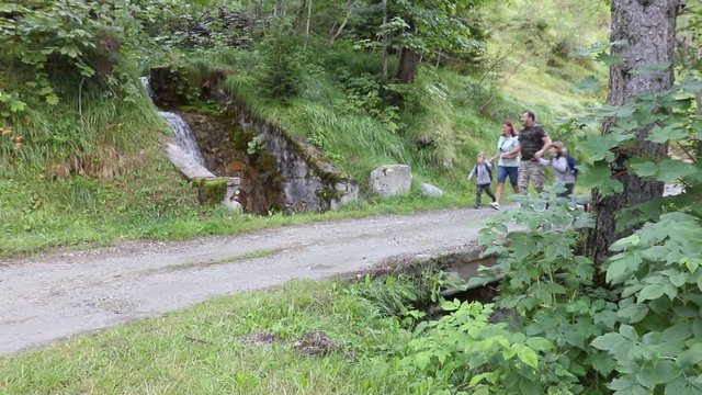 famiglia in montanga si ferma a guardare una cascata mentre stanno correndo