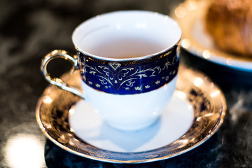 Espresso In China Cup On Saucer On Dark Table At Diner