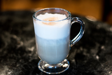 Cappuccino In Glass Mug On Dark Table At Diner