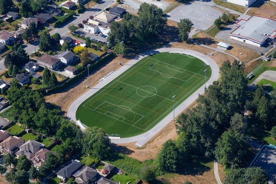Aerial view of a green soccer field in an Elementary School. Taken in Burnaby, Greater Vancouver, BC, Canada.