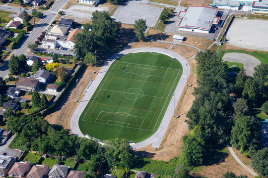 Aerial view of a green soccer field in an Elementary School. Taken in Burnaby, Greater Vancouver, BC, Canada.