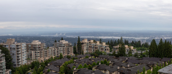 Aerial view of residential homes and buildings on top of Burnaby Mountain. Taken in Vancouver, British Columbia, Canada.