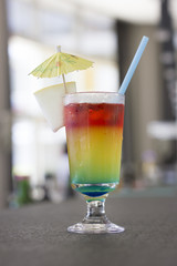 Bright cocktail with umbrella and on the bar rack