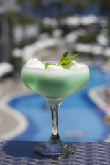 Blue cocktail in a beautiful glass with ice cream and green mint leaves