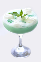 Blue cocktail in a beautiful glass with ice cream and green mint leaves. Isolated