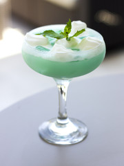 Blue cocktail in a beautiful glass with ice cream and green mint leaves