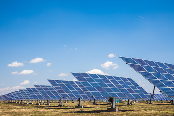 Side view of solar panels on blue sky with clouds