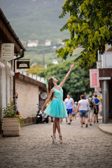 Fototapeta na wymiar Elegant ballet dancer girl dancing ballet in the city