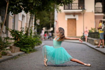 Elegant ballet dancer girl dancing ballet in the city
