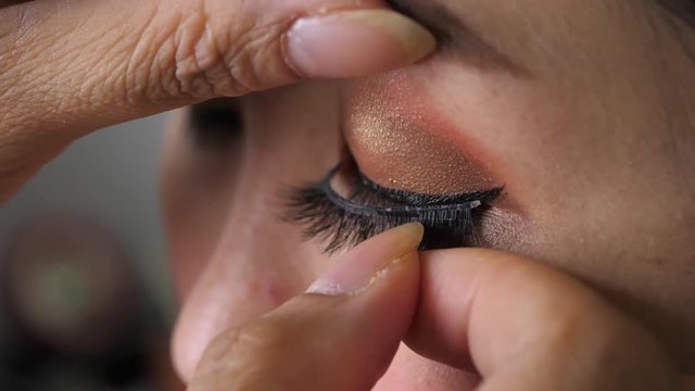 slow motion, makeup beauty paste long false eyelash on eye