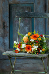 Fototapeta na wymiar Bunter Blumenstrauß auf einem alten Gartenstuhl