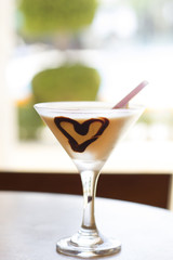 Cocktail with a chocolate heart and a pink straw