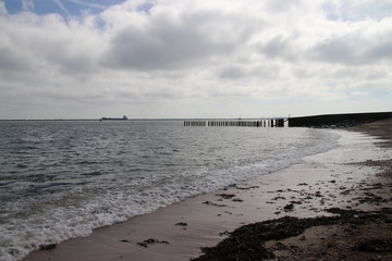 Fototapeta premium Waves on the shore at the sea at the Maasvlakte in Rotterdam, The Netherlands.