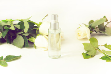 clear perfume cosmetic bottle glass package mockup with flower rose white and green natural leaf on background