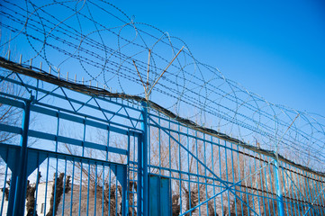 Fototapeta premium Barbed fence around prison walls