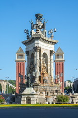 Fototapeta na wymiar Fountain and Venetian towers in center of Spain square in Barcelona