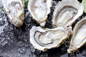 Rolgordijnen Eetkamer verse open oesters met ijs op leisteen