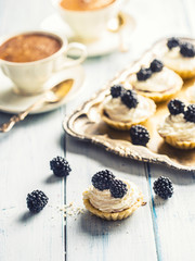 Mini tartlets with blackberries whipped cream and coffee.