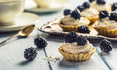 Mini tartlets with blackberries whipped cream and coffee.