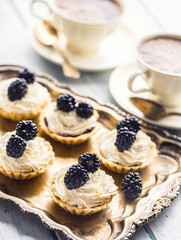 Mini tartlets with blackberries whipped cream and coffee.