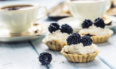 Mini tartlets with blackberries whipped cream and coffee.