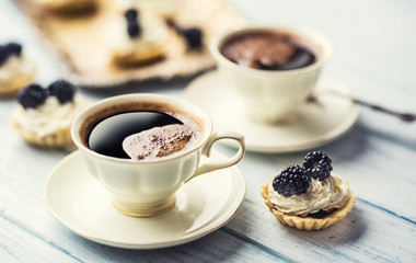Mini tartlets with blackberries whipped cream and coffee.