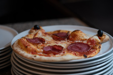 Kinder Margarita Pizza mit Gesicht aus dem Pizzaofen auf einem Teller und in einer Schachtel
